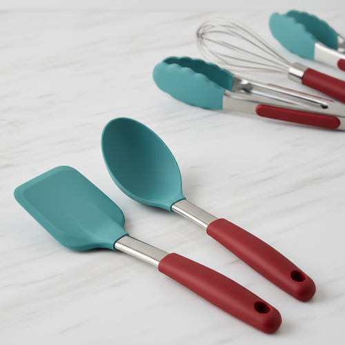Close-up of silicone spatula and spoon with colorful handles on marble surface